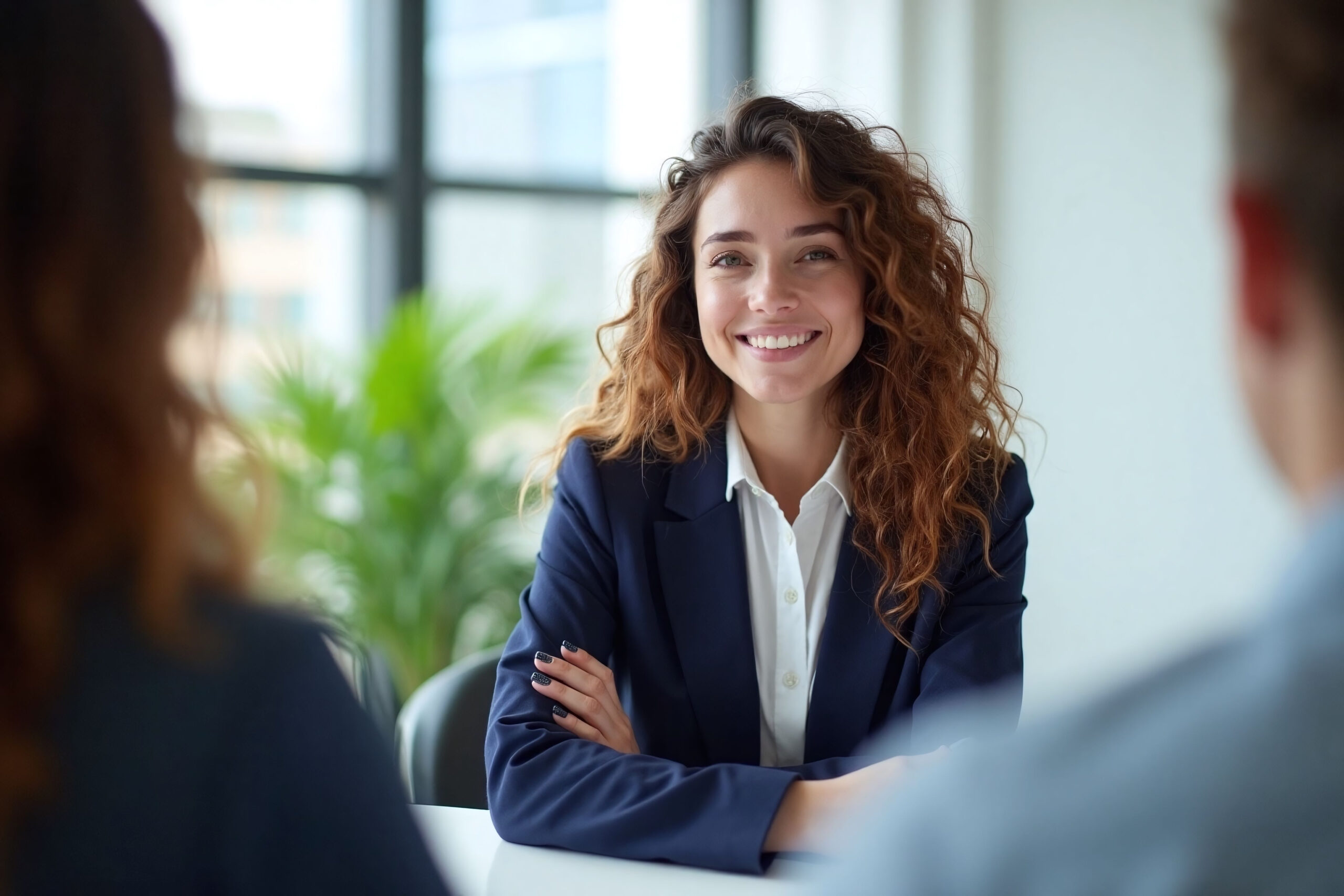 professional woman in business setting at conference table smiling young court reporter with CRC support team on screen